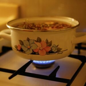 A vintage floral pot cooking on a gas stove, creating a warm, cozy kitchen ambiance.